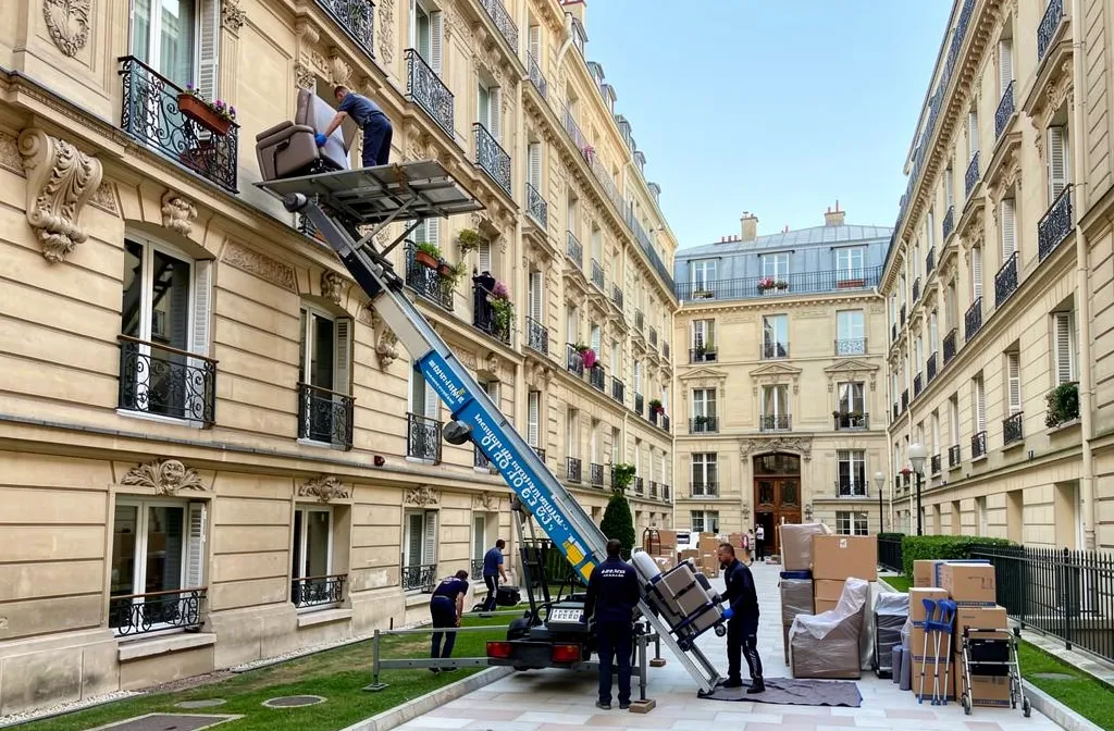 Déménagement paris 18 : déménageurs installant un monte-meubles et transportant des meubles dans une cour d’immeuble du 18e arrondissement de Paris.