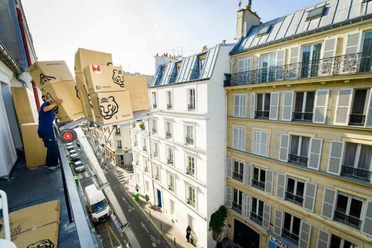 Chargement et transport de cartons sur un monte-meuble devant des immeubles parisien s.